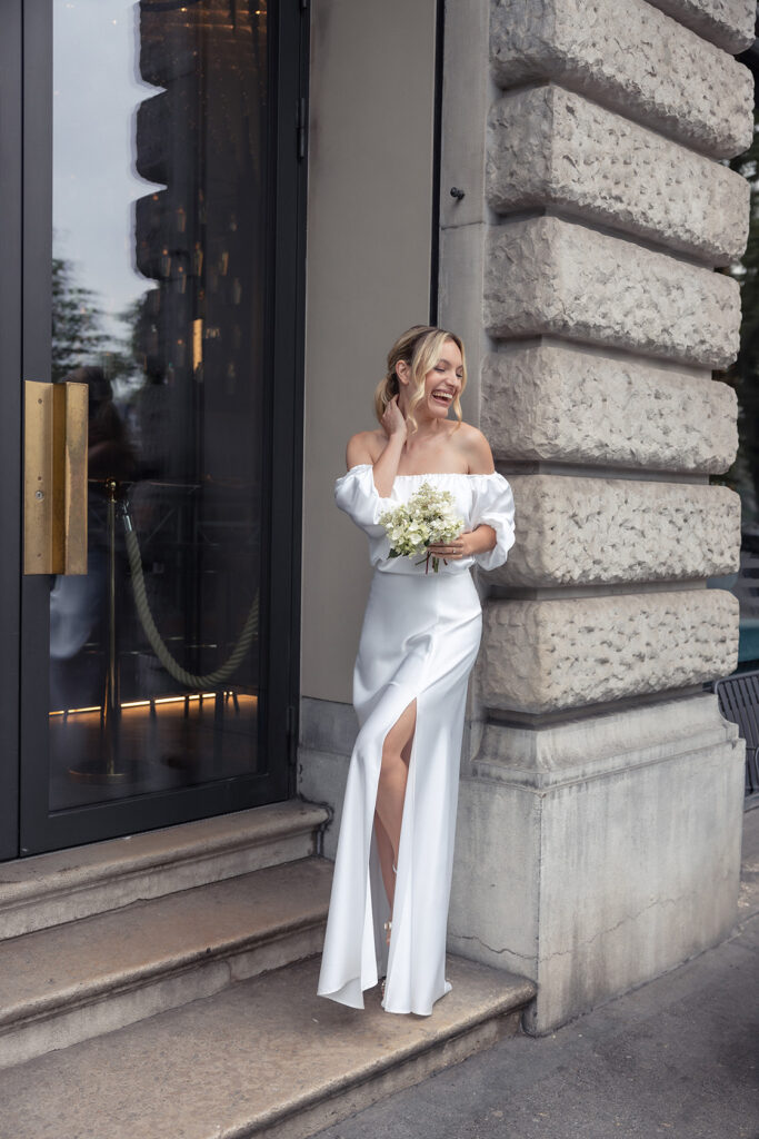 Lachende Braut in einem modernen Hochzeitskleid, erhältlich bei Zauberbraut Zürich