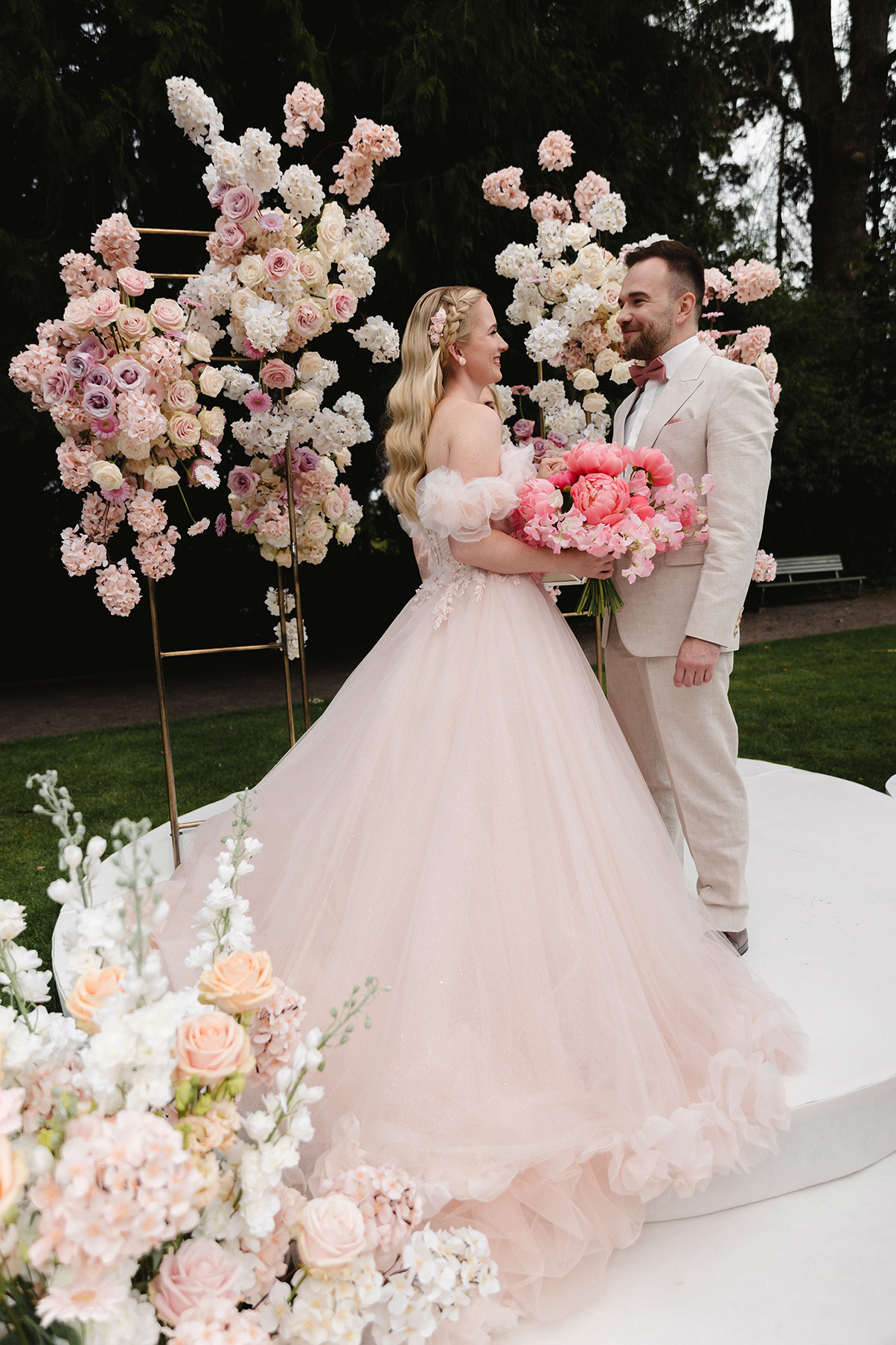 Hochzeitspaar auf dem Altar, die Braut trägt ein rosa Hochzeitskleid mit viel Tüll im Prinzessinnen Stil